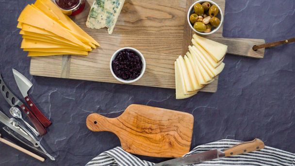 Acostado. Organizar queso gourmet, galletas y frutas en una tabla para una tabla de queso grande. - Foto, imagen
