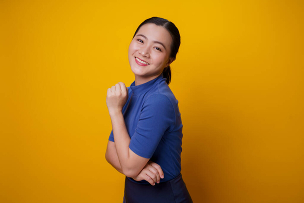 Счастливая азиатка с зубастой улыбкой на желтом фоне. - Фото, изображение
