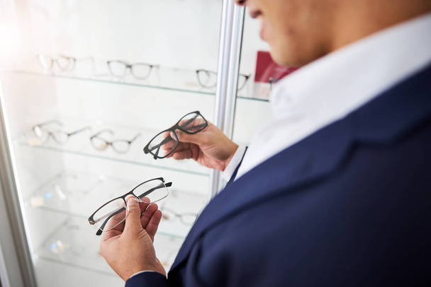 Man looking at trendy spectacles in his hands - Fotó, kép
