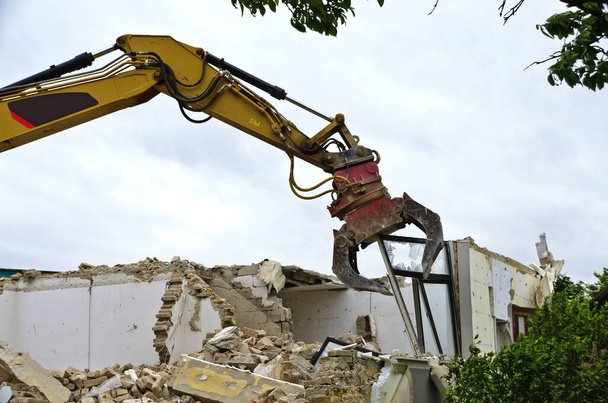 Demontage eines Fensters durch einen Bagger beim Abriss eines Wohnhauses in Österreich - Foto, Bild