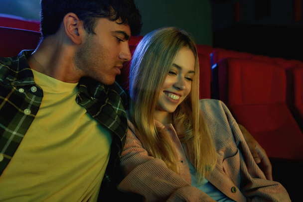 Portrait of charming couple, attractive young man and woman watching film together, having romantic movie date at the cinema - Valokuva, kuva