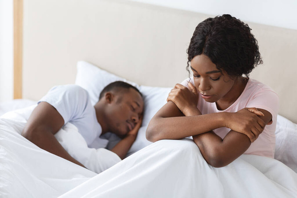 Depressed black woman dont sleep while her boyfriend sleeping - Foto, Bild