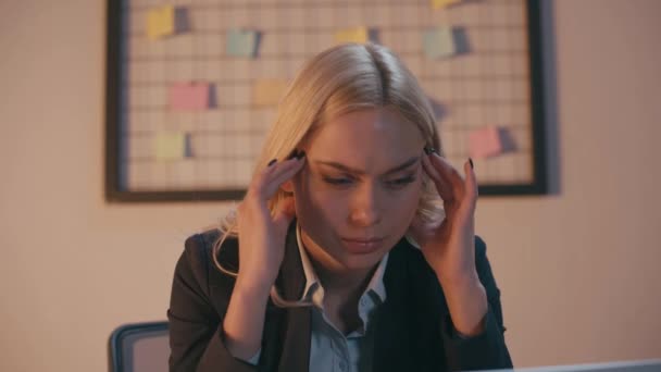 Blonde Geschäftsfrau berührt Schläfen, während sie unter Kopfschmerzen leidet  - Filmmaterial, Video
