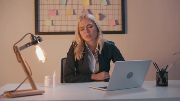 blonde businesswoman suffering from stomach ache in office - Filmagem, Vídeo