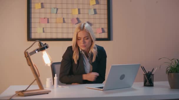donna d'affari malata sensazione di freddo e utilizzando il termometro digitale in ufficio - Filmati, video