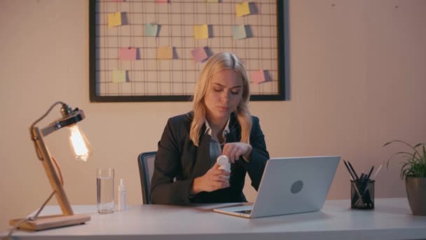 zieke zakenvrouw neemt pil en drinkwater in het kantoor - Video