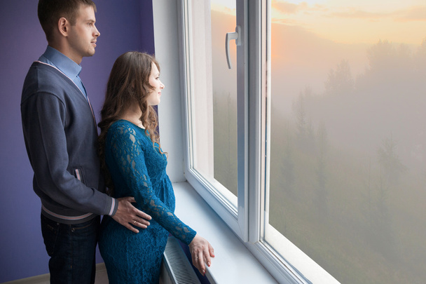 O casal está a olhar pela janela
 - Foto, Imagem