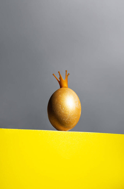 Golden egg in crown on yellow and gray background, easter concept while covid-19 isolated - Foto, immagini