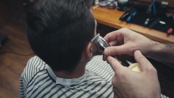 Парикмахер с помощью триммера и кисти на человека в парикмахерской  - Кадры, видео