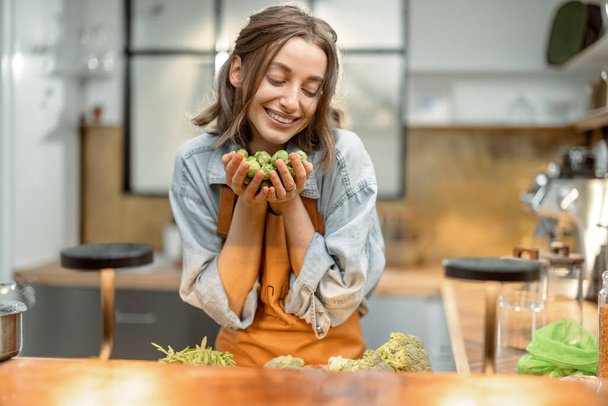 Γυναίκα με φρέσκα λαχανάκια Βρυξελλών στην κουζίνα - Φωτογραφία, εικόνα