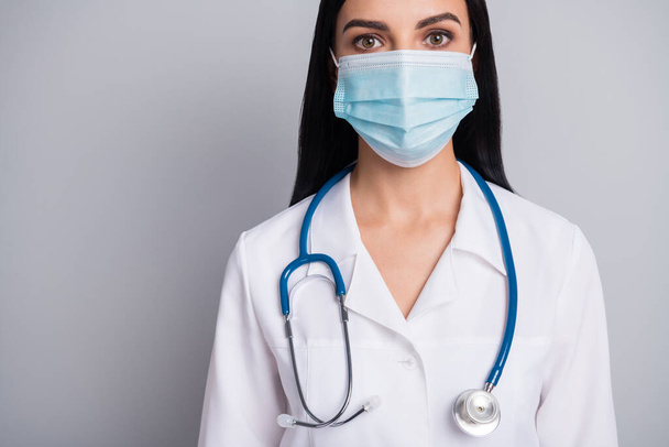 Καλλιεργημένη φωτογραφία του αξιολάτρευτο θετική γυναίκα θεραπευτής ντυμένος λευκό ομοιόμορφη αναπνευστήρα προσώπου απομονωμένο γκρι φόντο χρώμα - Φωτογραφία, εικόνα