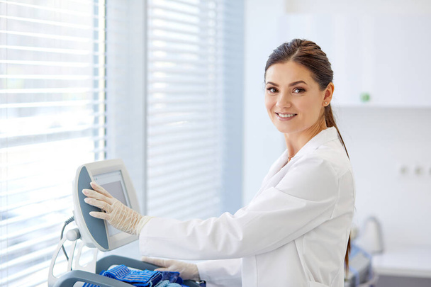 portrait of caucasian female doctor push buttons on medical equipment - Foto, immagini