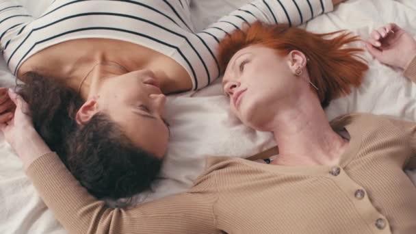 високий кут зору міжрасової лесбіянки пара говорить і лежить на ліжку
 - Кадри, відео