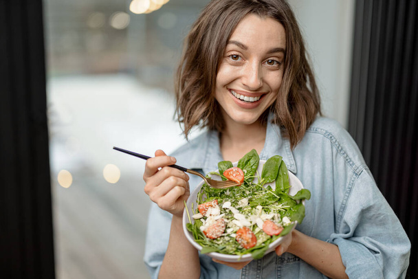 Mujer comiendo ensalada verde saludable en casa - Foto, Imagen