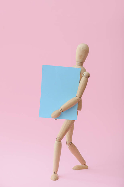 Dřevěná figurína s prázdným plakátem na barevném pozadí - Fotografie, Obrázek