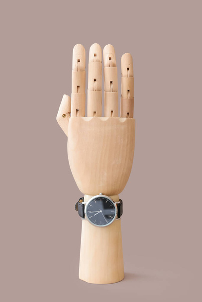 Wooden hand with watch on grey background - Photo, Image