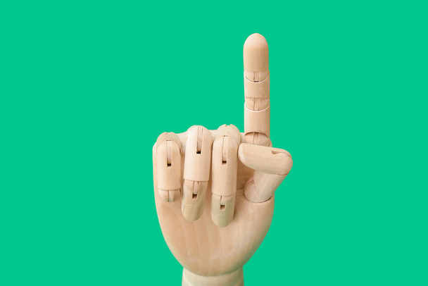 Wooden hand with raised index finger on color background - Φωτογραφία, εικόνα