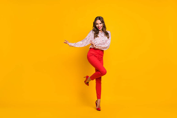 Full length portrait of charming lady partying raise knee wear red stilettos isolated on yellow color background - Foto, imagen