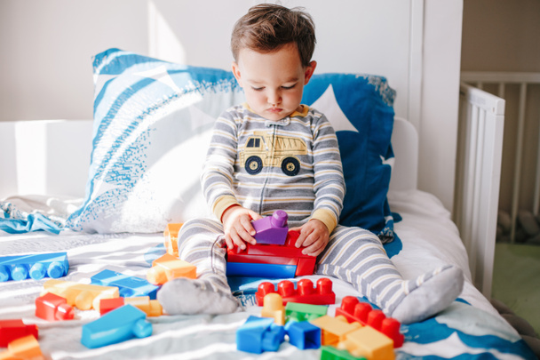 Cute baby toddler playing building with learning toy stacking blocks at home. Early age education. Kids hand brain and fine motor skills development. Logic activity for preschoolers.   - Foto, Imagem