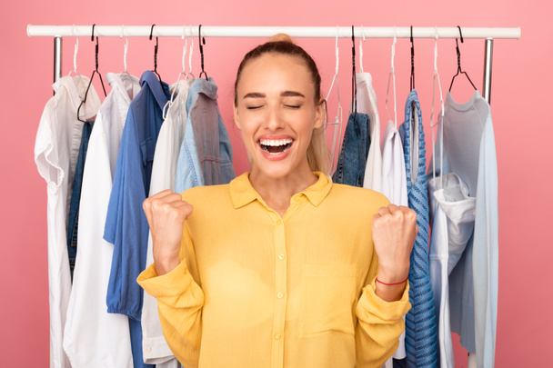 Przepełniona radością młoda kobieta krzyczy z radości wybierając ubrania - Zdjęcie, obraz