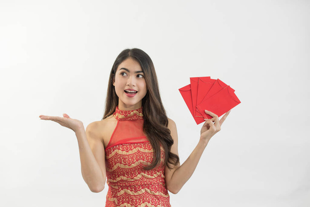 Young happy Asian woman holding red envelopes in Chinese New Year on white background - Foto, afbeelding