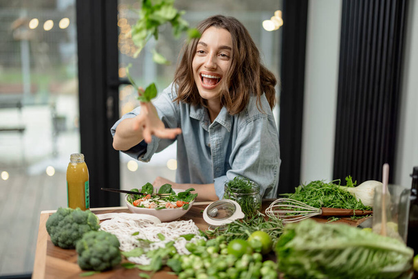 Woman cooking healthy green salad in kitchen - Photo, image