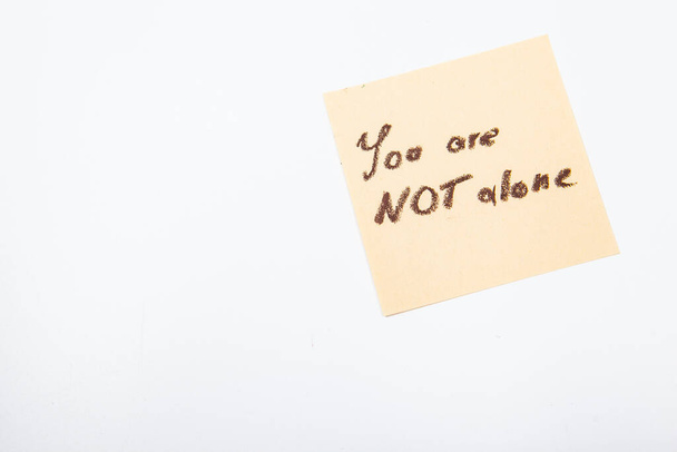 You are not alone inspirationsl note on yellow sticker memo - Photo, Image