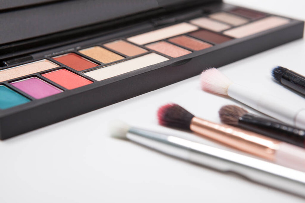 Eyeshadow makeup brushes near colorful eyeshadow pallete isolated - Zdjęcie, obraz