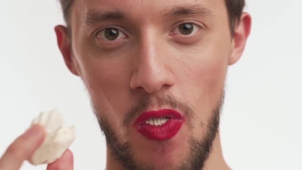 Detailní portrét bělošského transvestitského muže, jak jí. Sexy muž s černým vousem, namalované rty v červené barvě rtěnka zírat do kamery, otevřená ústa široká, dát lahodný marshmallow, žvýká s potěšením. - Záběry, video