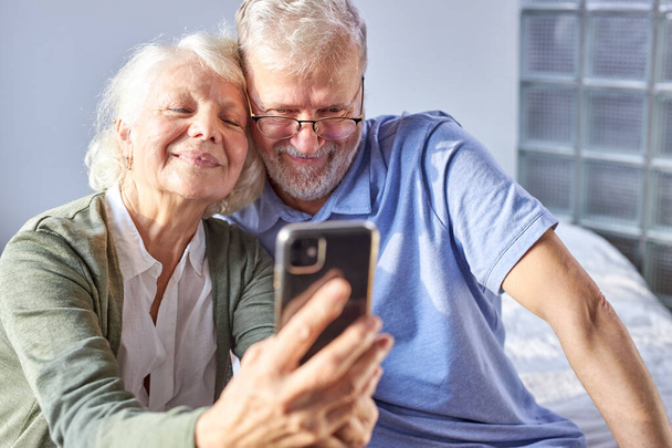 beautiful happy elderly couple taking photo on smartphone - Valokuva, kuva