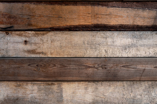 oud gebarsten houten hek. horizontale lijnen. ruwe oppervlaktestructuur - Foto, afbeelding