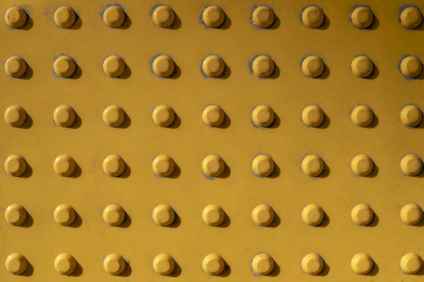 old dusty metallic bright yellow wall with rivets with shadows. rough surface texture - Foto, Imagem