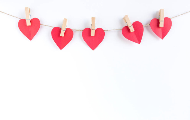 Red hearts paper on sack rope with clothespins on white background and copy space. - Photo, Image
