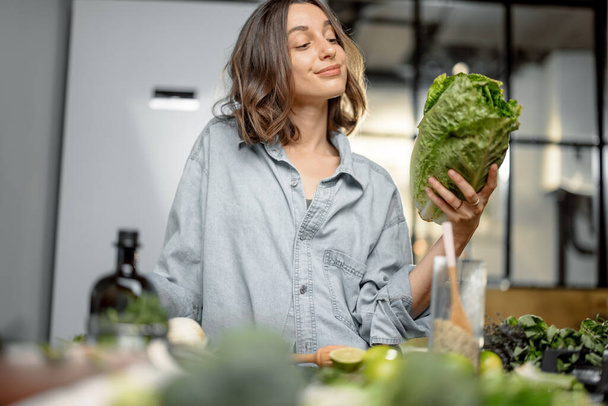 Woman with roman salad on the kitchen - Фото, изображение