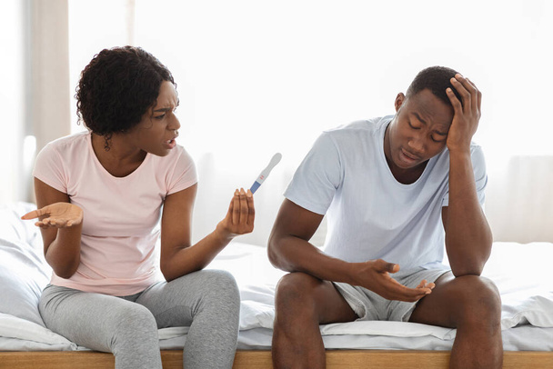 Boos zwarte vrouw met zwangerschapstest schreeuwen tegen haar vriend - Foto, afbeelding