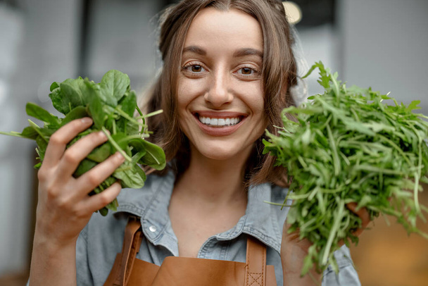 Femme avec des verts frais sur la cuisine - Photo, image