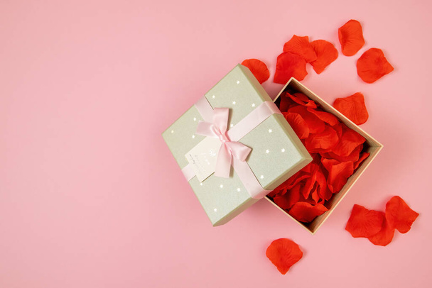 Open box filled with rose leaves on pink background - Φωτογραφία, εικόνα