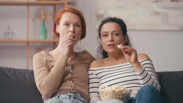multiculturele lesbische vrouwen kijken film en het eten van popcorn  - Video
