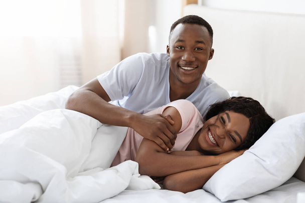szczęśliwy czarny para przytulanie w łóżko w dom - Zdjęcie, obraz