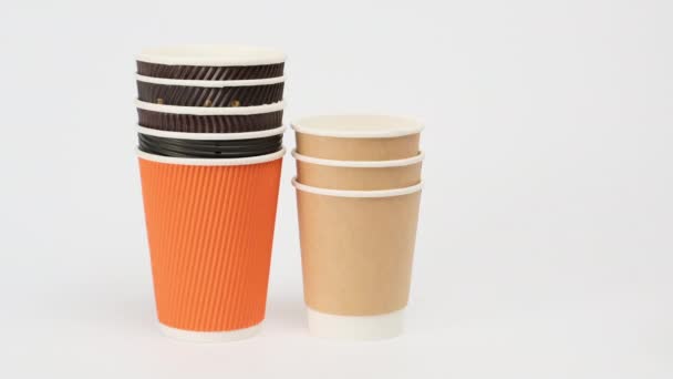 pila de tazas de papel desechables para café y té sobre un fondo blanco, pone a mano, cero residuos  - Metraje, vídeo