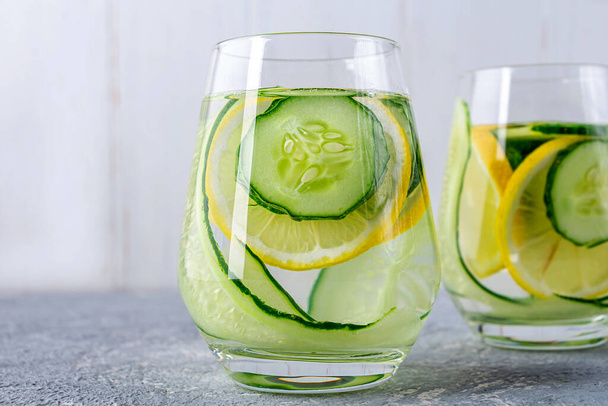Fresh cool detox water drink with cucumber and lemon. Two glass of Lemonade with mint. Concept of proper nutrition and healthy eating. Fitness diet. Close up - Foto, Imagem