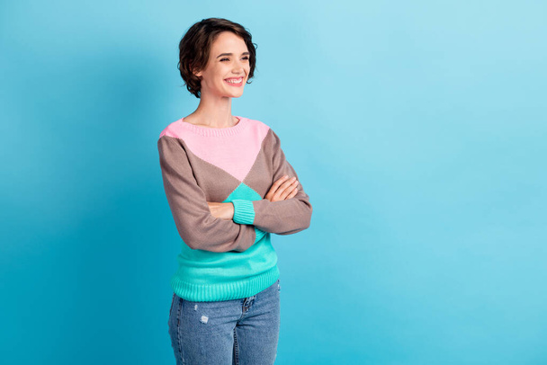 Photo portrait three fourths 3 4 angle of woman with crossed arms smiling isolated on pastel light blue colored background - Zdjęcie, obraz