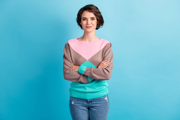 Photo portrait of smiling woman with folded hands isolated on pastel light blue colored background - 写真・画像