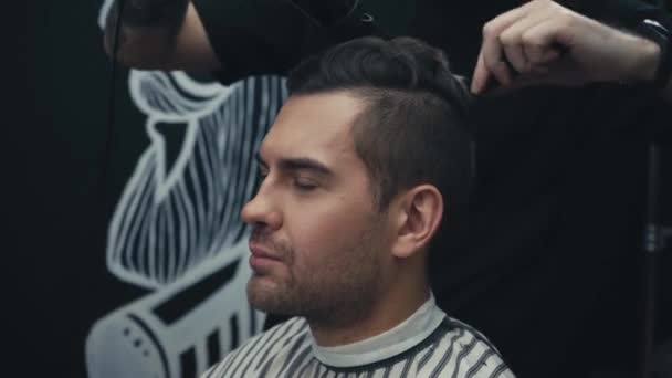 Barbeiro secagem e styling cabelo do cliente na barbearia  - Filmagem, Vídeo