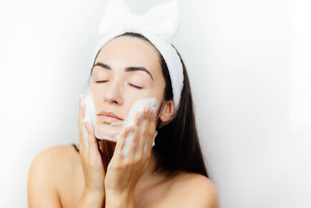 洗顔を適用する女性 - 写真・画像