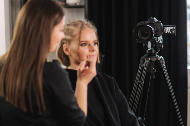 Gyönyörű nő szépség vlogger csinál kozmetikai smink bemutató barátjával a stúdióban - Fotó, kép