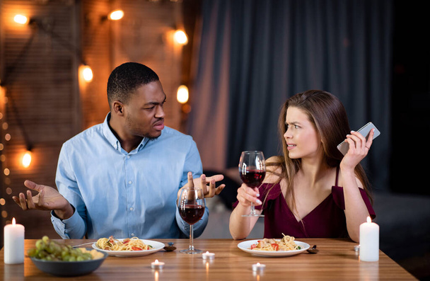 Annoyed Black Guy Arguing With His Girlfriend Busy With Cellphone On Date - Photo, Image