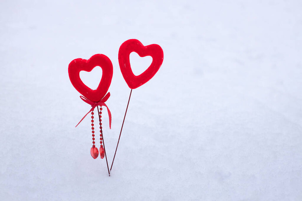 valentine's day concept, two red decorative velvet hearts on white fresh fluffy snow, 14 february winter holiday background - 写真・画像