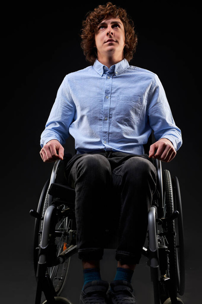 serious sick invalid man cant walk, sits alone on wheelchair - Foto, Bild