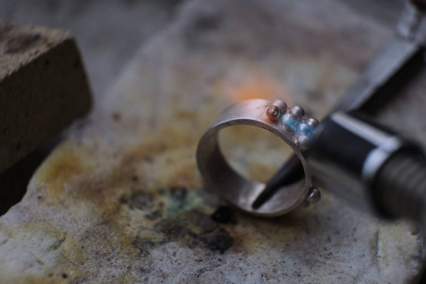 Macro shot. Craft jewelery making with professional tools. A handmade jeweler process, manufacture of jewellery. Melting metal - Photo, Image